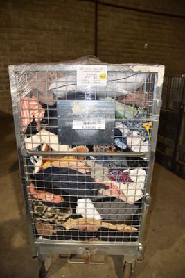 a metal cart with many items in it in a warehouse