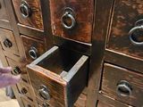 a person reaching for a drawer of drawers in a room