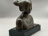 une image représentant une statue en bronze d'une femme posée sur un socle noir