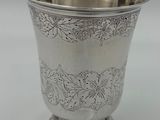a close up of a silver cup on a white surface