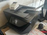 une imprimante posée sur un bureau à côté d'un téléphone portable