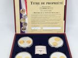 a set of four gold coins in a wooden case