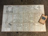 an old map of the city of paris with a book on the ground