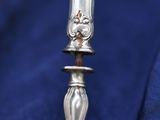 a silver spoon with a handle on a blue cloth