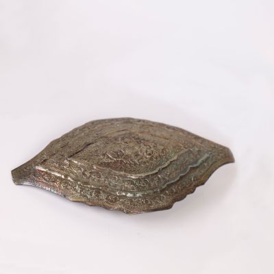 a metal object on a white surface with a white background
