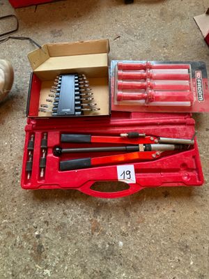 une caisse à outils rouge avec des outils sur le sol