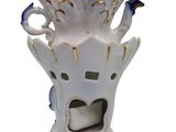 a white vase with a blue and gold decoration on it