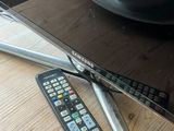 two remote controls on a table next to a television