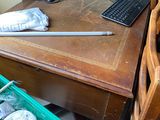 a wooden desk with a computer monitor and other items on it