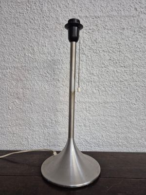 a close up of a metal table lamp on a wooden table