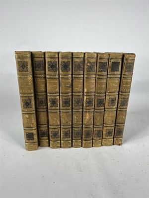 six vieux livres empilés les uns sur les autres sur une surface blanche