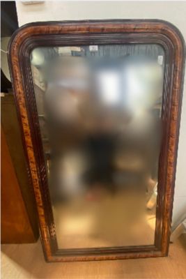a large mirror sitting on the floor next to a wall