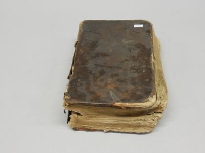 un vieux livre posé sur une table blanche