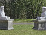 deux statues représentant une femme et un homme assis sur un banc