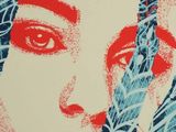 painting of a woman ' s face on a wall with red and blue paint