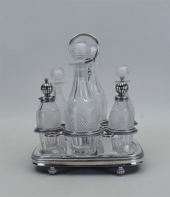 un plateau en argent sur lequel est posé une carafe en verre