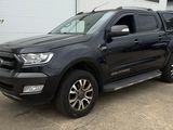 une photo d'un pick-up noir garé devant un immeuble
