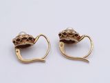 two pairs of gold earrings with pearls on them on a white surface