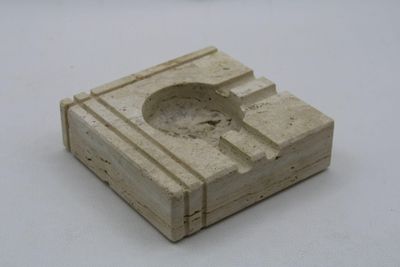 a stone ashtray with a hole in it on a white surface