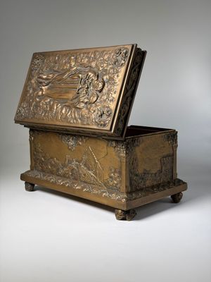 an antique wooden box with a carved design on the lid