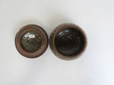 two brown and black vases sitting on top of a white table