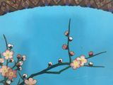 a blue plate with flowers on it on a table
