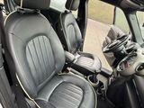 l'intérieur d'une voiture avec des sièges en cuir noir et un volant