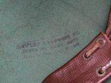 a close up of a brown leather bag with a tag on it