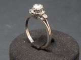 an image of a diamond ring sitting on top of a black stone