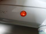 a close up of a white car with a red light on it