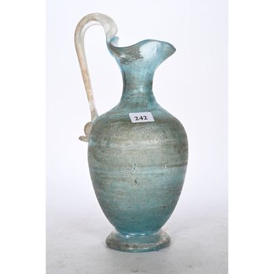 un vase bleu muni d'une anse blanche, posé sur une table