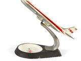 une maquette d'avion posée sur un socle, sur une surface blanche