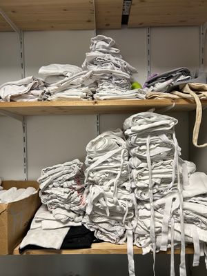 de nombreuses piles de linges blancs pliés sur les étagères