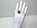 une main de mannequin blanche ornée d'une bague rouge