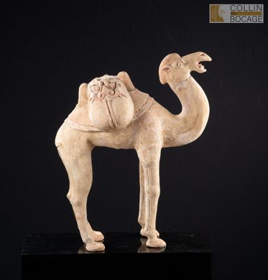 une vieille statue représentant un chameau avec une selle sur le dos