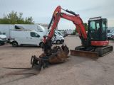 an image of a small excavator in a parking lot