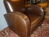 a brown leather chair sitting on a rug in a living room