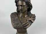 a bronze bust of a woman with a hat on her head