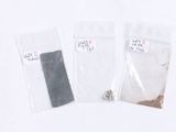 three bags of sand and a piece of metal on a table