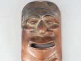 a brown mask on a white surface with a white background