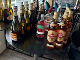 many bottles of alcohol sitting on a table in a room
