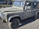 a grey land rover parked in a lot with other vehicles