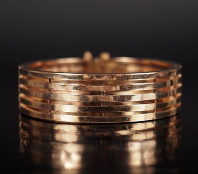 gros plan d'une bague en or sur une surface noire