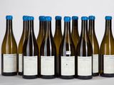 six bouteilles de vin sont alignées sur une table