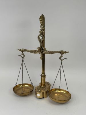 an antique brass scale with a bird on top of it