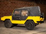 a yellow jeep with a black cover parked in front of a brick wall
