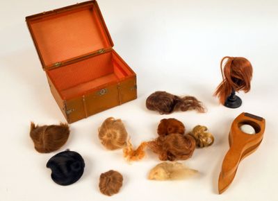 une boîte contenant une mèche de cheveux et une paire de ciseaux