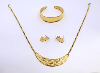 a close up of a necklace, earrings and ring on a white surface