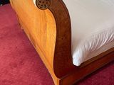 a bed with a wooden frame and white sheets on it