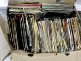 a cardboard box full of records on the floor
